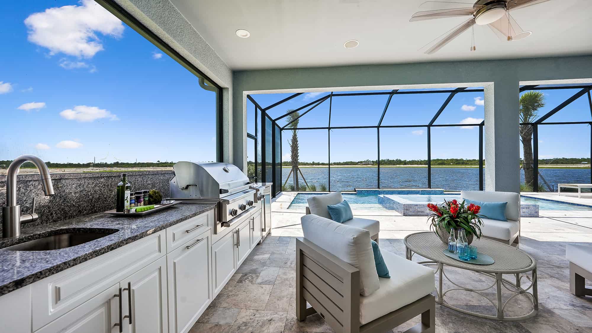 Outdoor grill and entertainment area with screened-in pool at Sky Sail Bright Meadow by Neal Communities