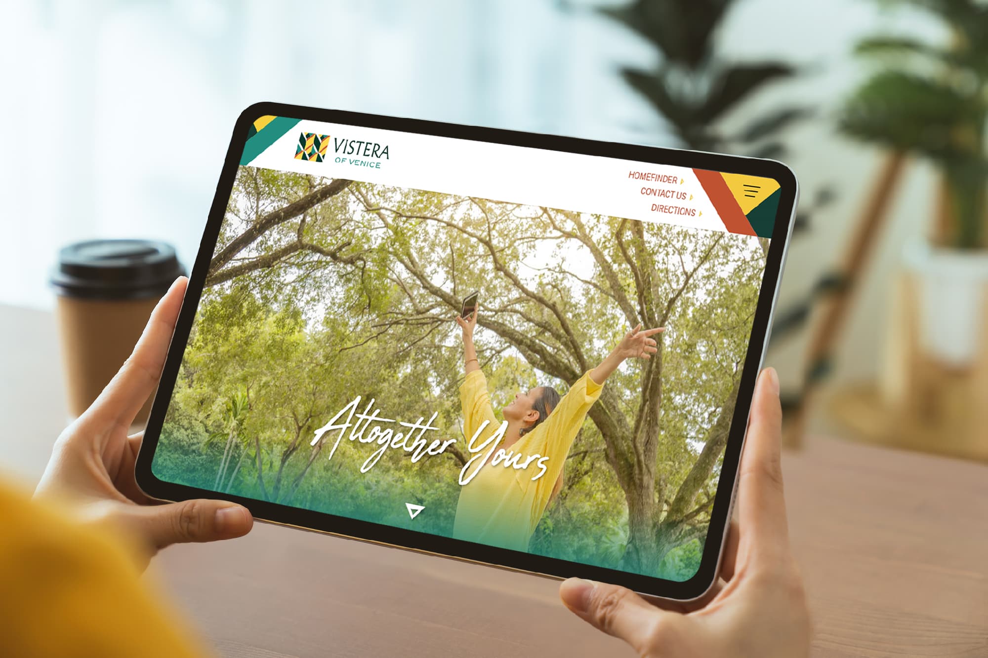 Hands holding tablet showcasing Vistera website